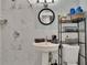 Bright bathroom featuring marble-look tile, pedestal sink with round mirror, and decorative towels on rack at 5081 72Nd N Ave, Pinellas Park, FL 33781
