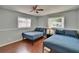 Bright bedroom features hardwood floors, a ceiling fan, and two beds with blue quilted covers at 5081 72Nd N Ave, Pinellas Park, FL 33781