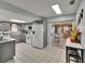 Modern kitchen with gray cabinets, tile backsplash, white appliances, and access to dining area at 5081 72Nd N Ave, Pinellas Park, FL 33781