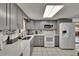 Updated kitchen with gray cabinets, white appliances, and tile backsplash under a large skylight at 5081 72Nd N Ave, Pinellas Park, FL 33781
