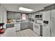 Stylish kitchen featuring gray cabinets, white appliances and lots of countertop space at 5081 72Nd N Ave, Pinellas Park, FL 33781