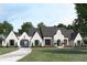 A charming single-story home boasts white brick, elegant archways, dark shutters, and a meticulously manicured lawn at 511 Avonwood, Tampa, FL 33625