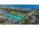 Aerial view of community tennis courts, swimming pool, and surrounding buildings and landscaping at 5191 Salmon Se Dr # C, St Petersburg, FL 33705