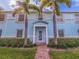 Exterior shot of a charming blue apartment building with well-manicured lawn, palm trees, and walkway to entrance at 5191 Salmon Se Dr # C, St Petersburg, FL 33705