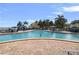 Large community pool and deck with lounge chairs surrounded by lush tropical greenery at 5191 Salmon Se Dr # C, St Petersburg, FL 33705