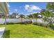 Spacious backyard featuring green grass, privacy fence, and mature palms at 5235 42Nd S St, St Petersburg, FL 33711