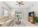 Comfortable living room with neutral tones, ceiling fan, tile floors, and sliding door to patio at 5235 42Nd S St, St Petersburg, FL 33711