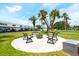 Outdoor seating area with firepit surrounded by lush tropical trees and community buildings at 5356 81St N St # 26, St Petersburg, FL 33709
