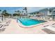 Inviting community pool with lounge chairs, surrounded by tropical palm trees, and nearby buildings at 5356 81St N St # 26, St Petersburg, FL 33709