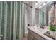 Well-lit bathroom with gray vanity, shower-tub combo and decorative green shower curtain at 5538 Spanish Moss Cv, Bradenton, FL 34203