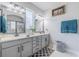 Bright, functional bathroom featuring dual sinks, vanity, mirror, and walk-in shower at 5538 Spanish Moss Cv, Bradenton, FL 34203