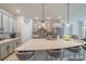 Modern kitchen with gray cabinets, stainless steel appliances, mosaic backsplash, and a large quartz island with seating at 5538 Spanish Moss Cv, Bradenton, FL 34203