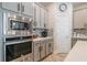 Contemporary kitchen featuring stainless appliances, gray cabinets, and stylish backsplash against light wood flooring at 5538 Spanish Moss Cv, Bradenton, FL 34203