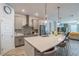 Open kitchen featuring gray cabinets, stainless appliances, quartz countertops, and island seating at 5538 Spanish Moss Cv, Bradenton, FL 34203