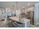 Spacious kitchen featuring gray cabinets, stainless appliances, island with seating and light wood flooring at 5538 Spanish Moss Cv, Bradenton, FL 34203
