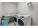 Bright laundry room featuring a modern washer and dryer, utility sink, white wire shelving and neutral flooring at 5538 Spanish Moss Cv, Bradenton, FL 34203
