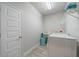 Well-lit laundry room equipped with a utility sink, washer, dryer, upper shelving, and neutral flooring at 5538 Spanish Moss Cv, Bradenton, FL 34203