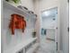 Hallway mudroom featuring bench with storage, overhead shelving, and access to the laundry room with machines and sink at 5538 Spanish Moss Cv, Bradenton, FL 34203