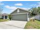 View of a one-story home, showing two car garage, driveway, and partial lawn in a neighborhood at 5825 Meadowpark Pl, Lithia, FL 33547