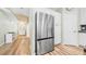 Kitchen with stainless steel refrigerator and pantry, with a light-filled hall with built-in cabinets in the background at 5825 Meadowpark Pl, Lithia, FL 33547