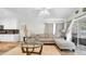 Open-concept living room with a comfortable couch, glass coffee table and access to the screened-in patio at 5825 Meadowpark Pl, Lithia, FL 33547