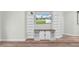 Living room with built-in white shelving unit, entertainment console and wood flooring, perfect for relaxing or entertaining at 5825 Meadowpark Pl, Lithia, FL 33547