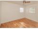 Bright bedroom featuring hardwood floors, a ceiling fan, and two windows for natural light at 601 N Franklin St, Plant City, FL 33563