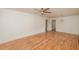 Bright living room featuring sleek hardwood floors, a ceiling fan, and freshly painted white walls at 601 N Franklin St, Plant City, FL 33563