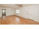Bright living room featuring sleek hardwood floors, a ceiling fan, and a freshly painted white door at 601 N Franklin St, Plant City, FL 33563