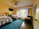 Bedroom with hardwood floors, two beds, a ceiling fan, and a large window overlooking the backyard at 6429 Gulfport Blvd. South Blvd, South Pasadena, FL 33707