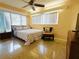 Bright bedroom featuring a ceiling fan, large windows, and minimalist decor at 6429 Gulfport Blvd. South Blvd, South Pasadena, FL 33707
