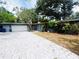 Charming single-story home with a brick driveway, lush landscaping, and light blue front door at 6429 Gulfport Blvd. South Blvd, South Pasadena, FL 33707