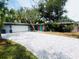 Charming home with a colorful flowering tree, brick driveway, and a light blue front door at 6429 Gulfport Blvd. South Blvd, South Pasadena, FL 33707