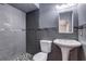 Modern bathroom features sleek gray tile in the walk-in shower and a pedestal sink at 7117 Wrenwood Cir, Tampa, FL 33617
