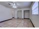 Bedroom with tile flooring, a ceiling fan, closet storage, and natural light from the windows at 7117 Wrenwood Cir, Tampa, FL 33617