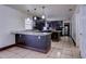 Kitchen with granite countertops, dark cabinetry, and tile flooring throughout at 7117 Wrenwood Cir, Tampa, FL 33617