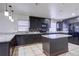 Kitchen featuring dark cabinets, granite countertops, a tile backsplash, and an island at 7117 Wrenwood Cir, Tampa, FL 33617