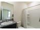 Bright bathroom with granite countertop vanity, a large mirror, and a shower with white tile surround at 7154 Steer Blade Dr, Zephyrhills, FL 33541