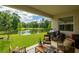 Covered patio area offering serene views of the lush backyard and pond, perfect for relaxation and outdoor dining at 7154 Steer Blade Dr, Zephyrhills, FL 33541