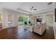 Relaxing living room with hardwood floors, a ceiling fan, a TV, and lots of natural light at 737 Winslow Park Blvd, Tarpon Springs, FL 34688