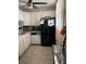 Bright kitchen with white cabinets and a ceiling fan is equipped with black appliances at 7465 Bay Island S Dr # 312, South Pasadena, FL 33707