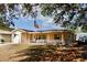Charming single-story home featuring a front porch, tidy landscaping and an American flag at 8039 83Rd N St, Seminole, FL 33777