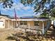 Inviting single-story home with a cozy front porch, solar panels and American flag at 8039 83Rd N St, Seminole, FL 33777