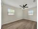 This bedroom has a ceiling fan, two windows, and wood flooring at 918 Skyview Dr, Brandon, FL 33510