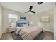 Bright bedroom features ceiling fan, wood floor, a painting, lamps, two windows, and modern decor at 918 Skyview Dr, Brandon, FL 33510