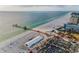 Expansive beach view with a pier, white sand, beachgoers, palm trees and ocean views at 94 Devon Dr, Clearwater Beach, FL 33767