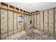 Unfinished kitchen with exposed framing, cinder block walls and a stainless steel refrigerator at 94 Devon Dr, Clearwater Beach, FL 33767