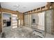 Unfinished kitchen featuring exposed framing, cinder block walls, and stainless steel refrigerator at 94 Devon Dr, Clearwater Beach, FL 33767