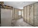 Unfinished kitchen featuring exposed framing, cinder block walls, and stainless steel refrigerator at 94 Devon Dr, Clearwater Beach, FL 33767
