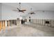 Large, bright living room awaiting renovation, featuring ceiling fans and an open-concept design at 94 Devon Dr, Clearwater Beach, FL 33767